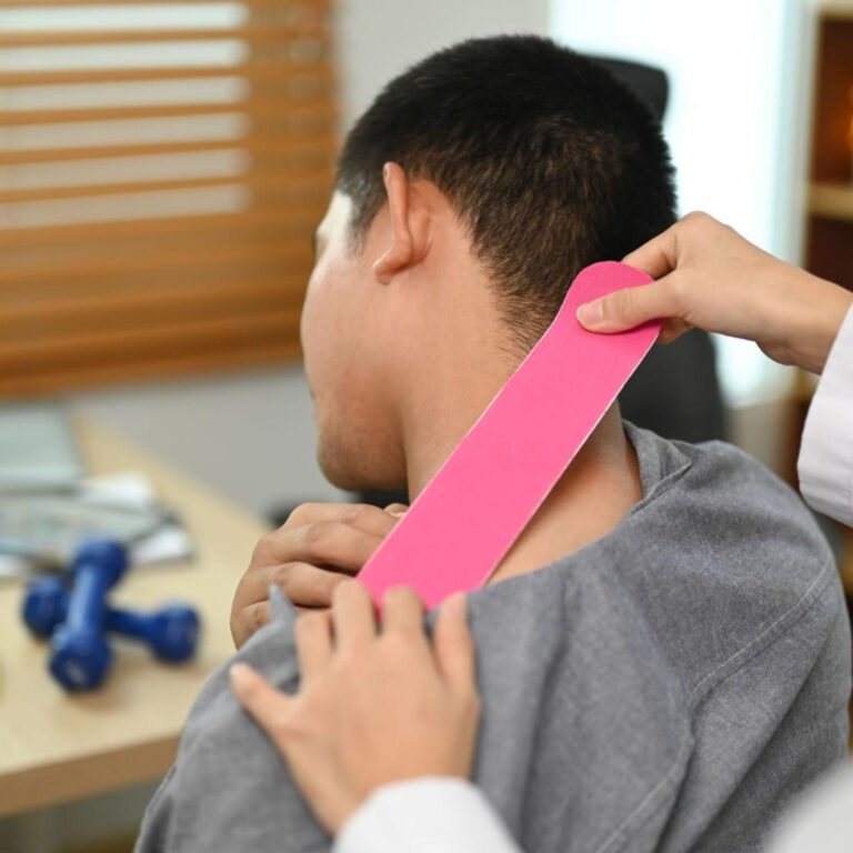 Clinician applying elastic taping for head and neck lymphedema management in a head and neck cancer patient